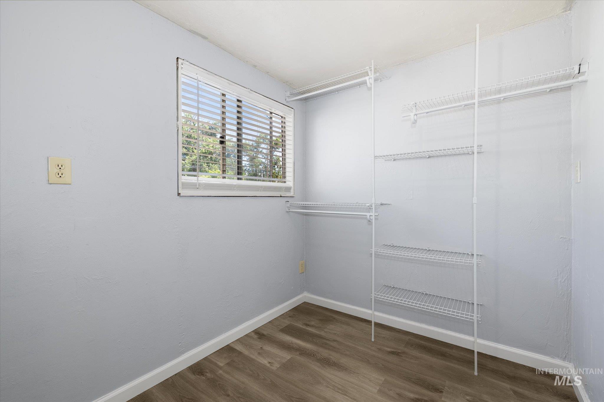 918 West 3rd Street Weiser, ID 83672 - Photo 26 of 36 Interior room with wood-finish flooring, light blue walls, and white baseboards