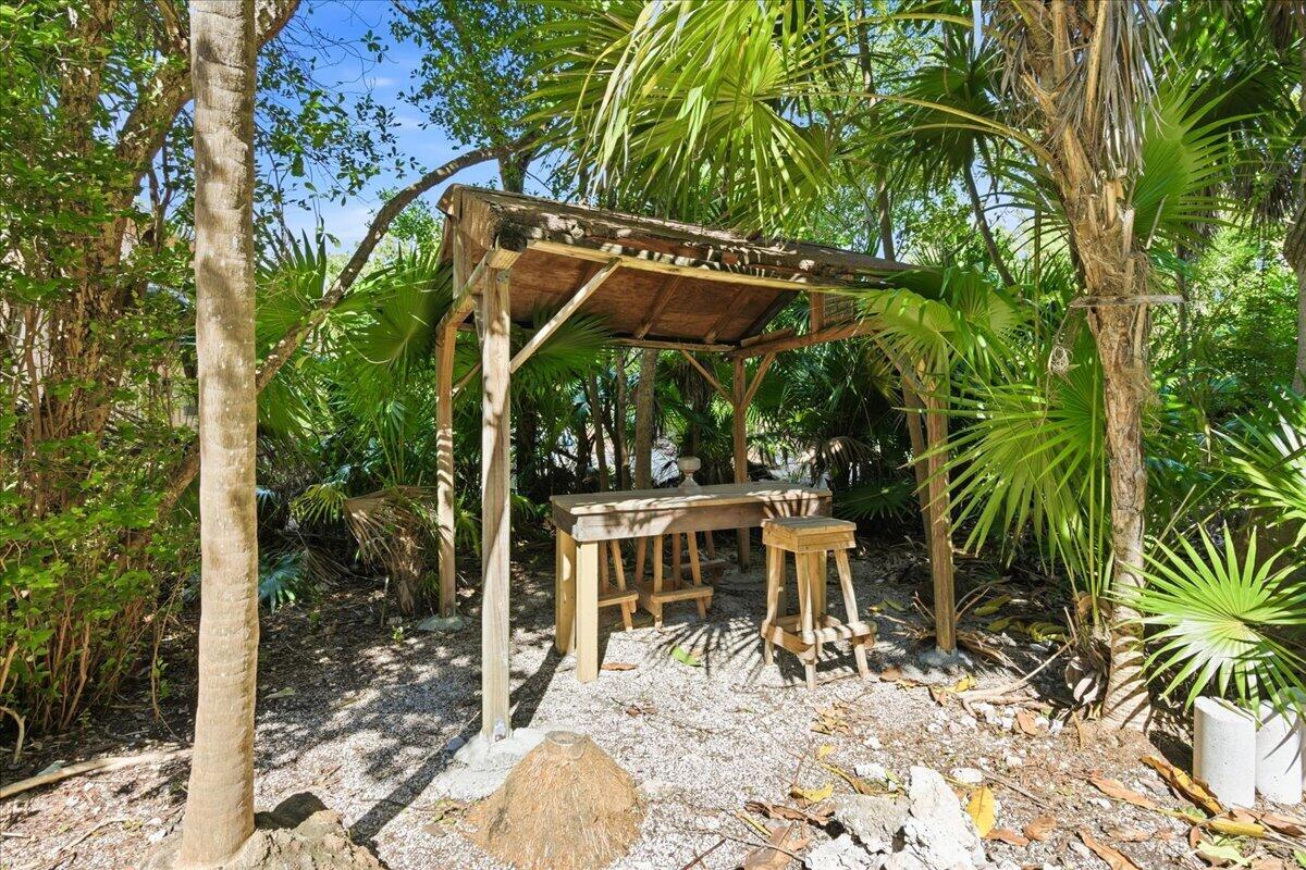 22 Stirrup Key Road Marathon, FL 33050 - Photo 10 of 48 a view of backyard with a table and chairs under an umbrella