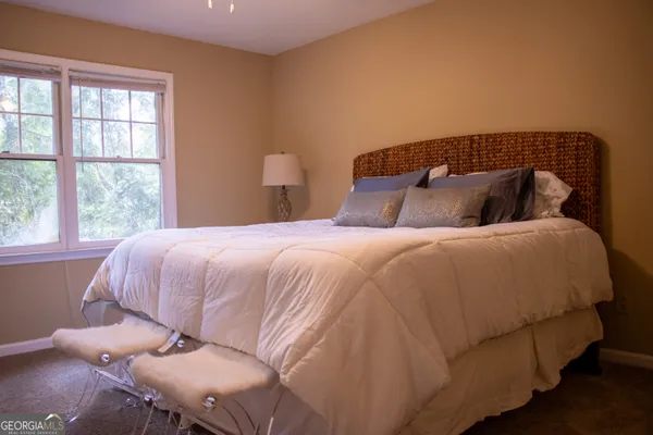 a large bed sitting in a bedroom next to a window