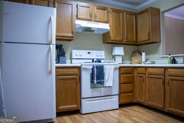 a kitchen with stainless steel appliances granite countertop a refrigerator stove a sink and dishwasher with wooden floor