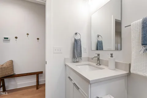 a kitchen with stainless steel appliances a refrigerator a stove a sink dishwasher and white cabinets with wooden floor