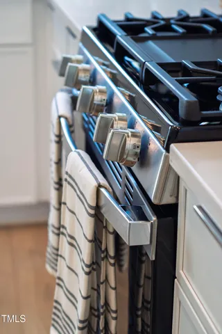 a kitchen with a stove and a wooden floor