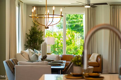 a view of a dining room with furniture a chandelier and wooden floor