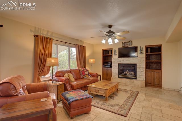 8252 Tompkins Road Peyton, CO 80831 - Photo 15 of 50 Living Room with in wall shelving, Gas Fireplace and Walk out to fabulous Patio.