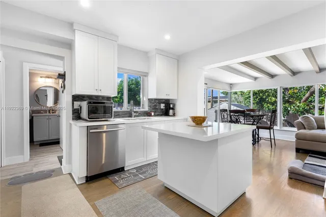 a kitchen with stainless steel appliances a stove a sink a oven a dining table and chairs