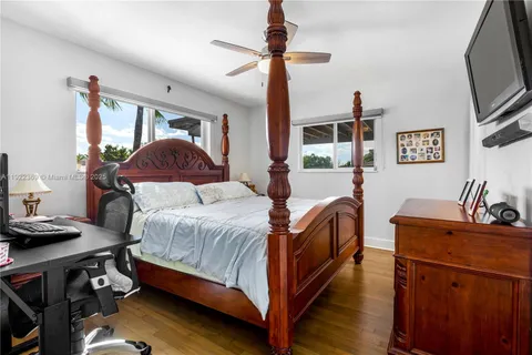 a bedroom with a bed and a flat tv screen on dresser