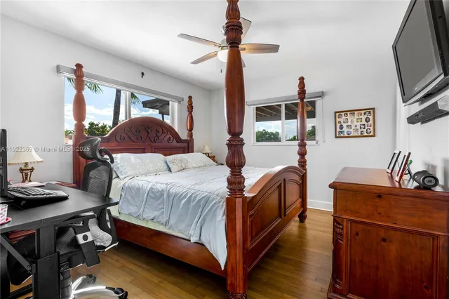 a bedroom with a bed and a flat tv screen on dresser