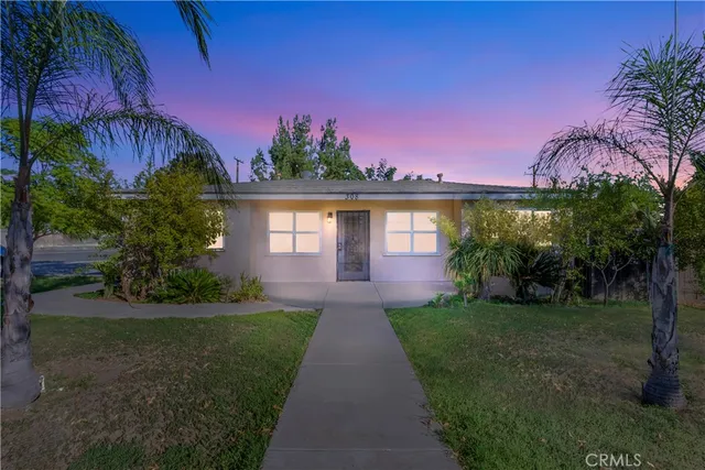 a front view of a house with a yard and potted plants