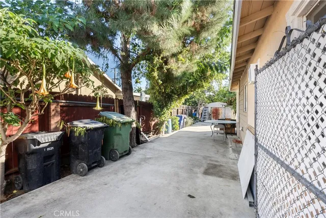 a view of a chair with potted plants in front of house