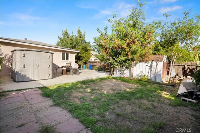 a view of a house with backyard and a tree