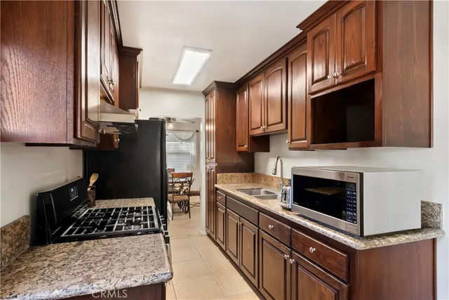 a kitchen with stainless steel appliances granite countertop a stove a refrigerator and a cabinets