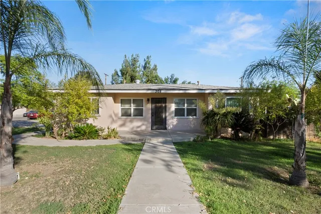 a front view of a house with a yard and potted plants