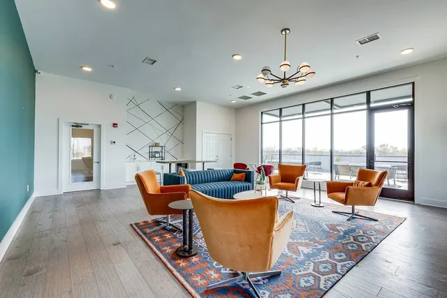a living room with furniture kitchen view and a large window