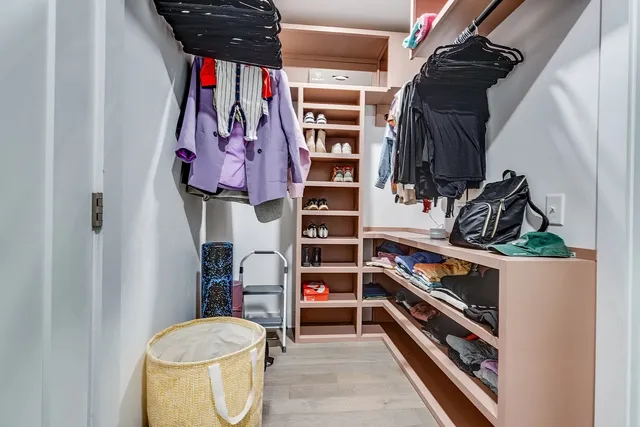 a view of walk in closet with clothes and shoes