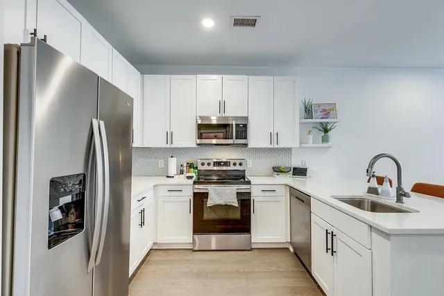 a kitchen with stainless steel appliances granite countertop a refrigerator sink and stove