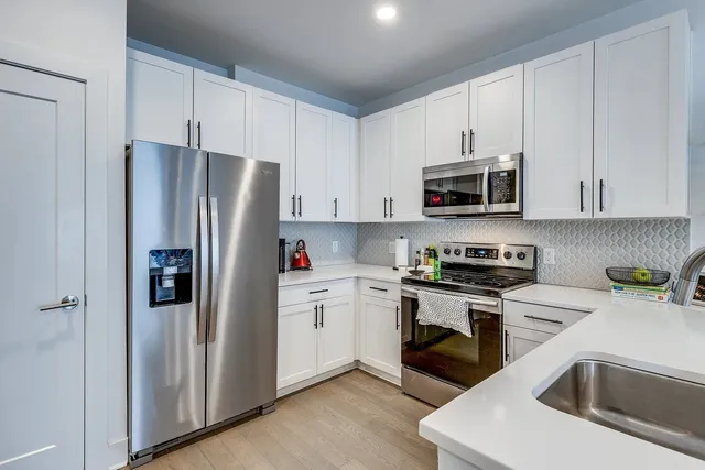 a kitchen with stainless steel appliances granite countertop a refrigerator stove and sink