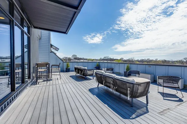 a view of a roof deck with dining table and chairs with wooden floor