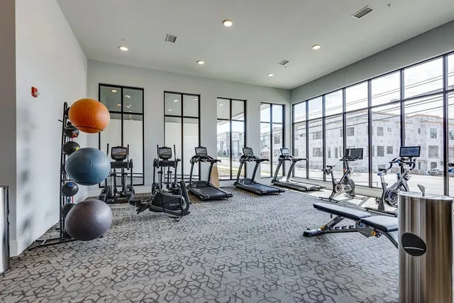 a view of a room with gym equipment and floor to ceiling window