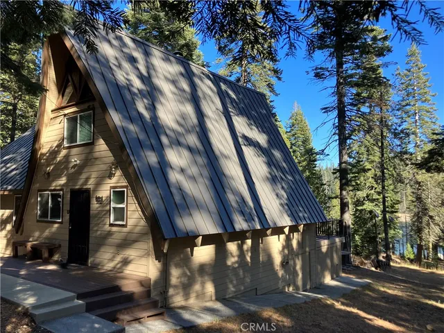 a view of a house with a small yard and wooden fence