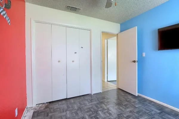 a room with a black white checkered floor with a gaming machine and a rug