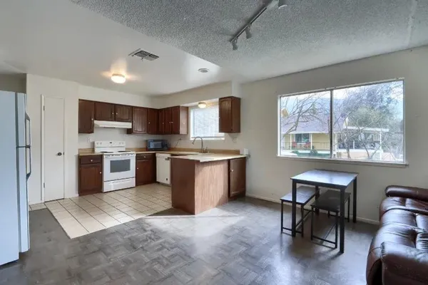 a large kitchen with stainless steel appliances granite countertop a stove granite counter tops and a view of living room with a large window