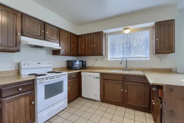 a kitchen with a stove sink and cabinets