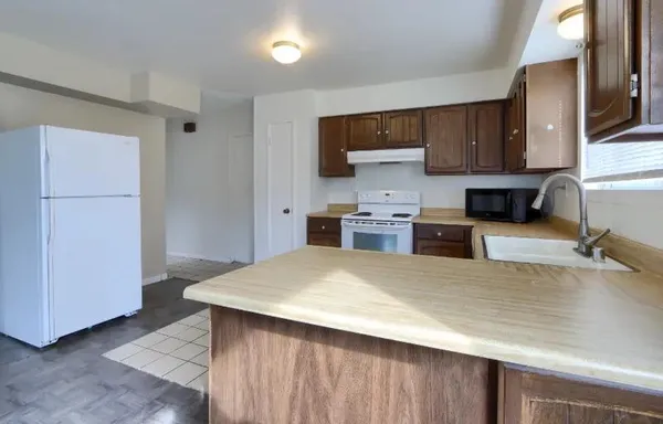 a kitchen with stainless steel appliances a refrigerator a sink a stove a microwave and cabinets