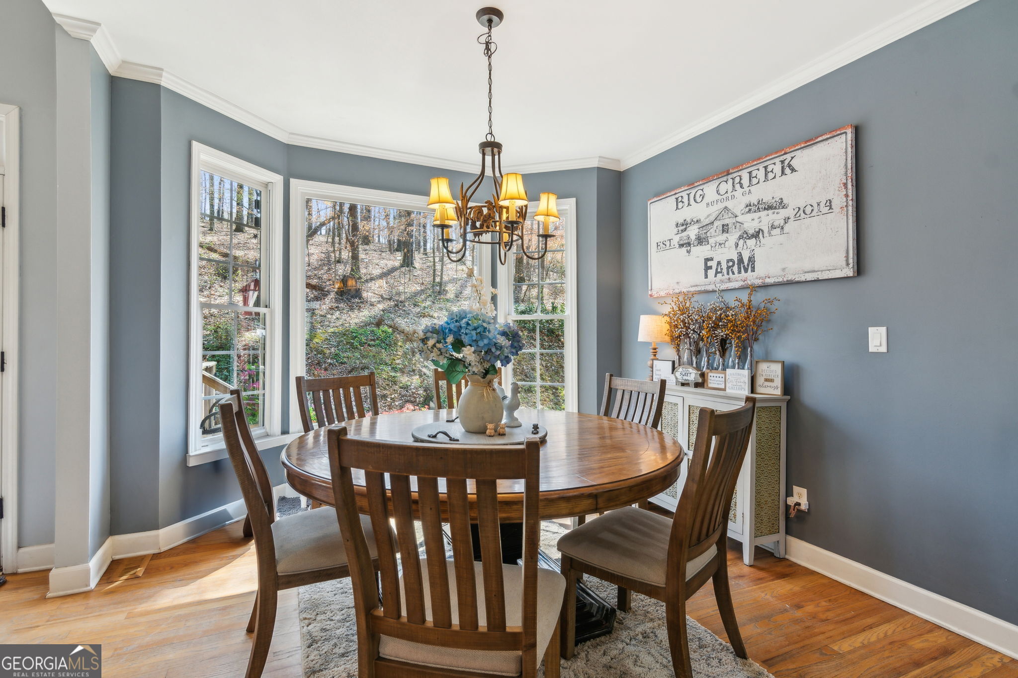 5388 Frazer Road Buford, GA 30518 - Photo 18 of 100 a dining room with furniture a chandelier and wooden floor