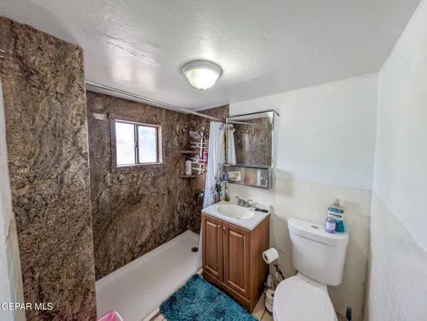 a bathroom with a sink toilet mirror vanity and bathtub