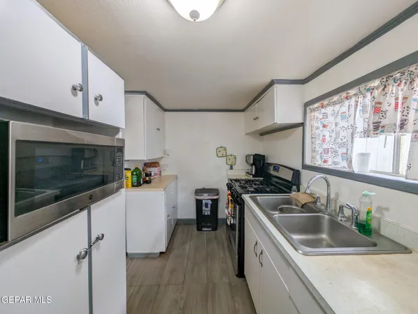 a kitchen that has a sink and a stove top oven