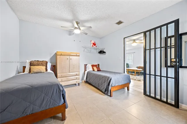 a bedroom with a bed and a refrigerator