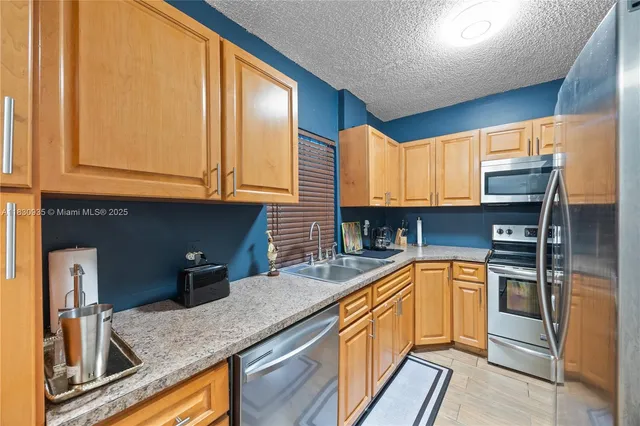 a kitchen with sink refrigerator and cabinets