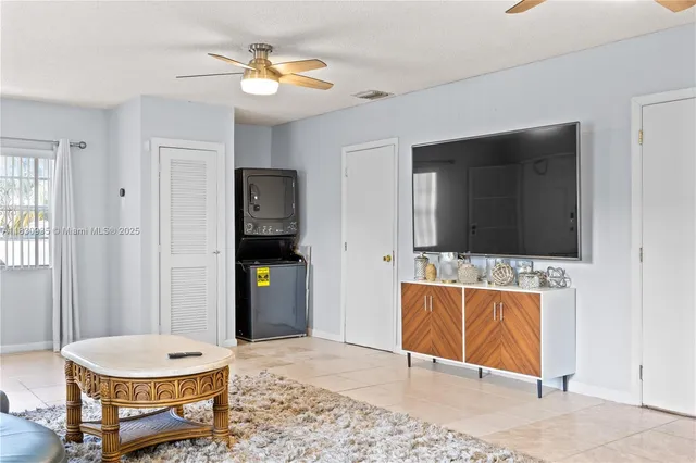 a living room with a flat screen tv and kitchen view