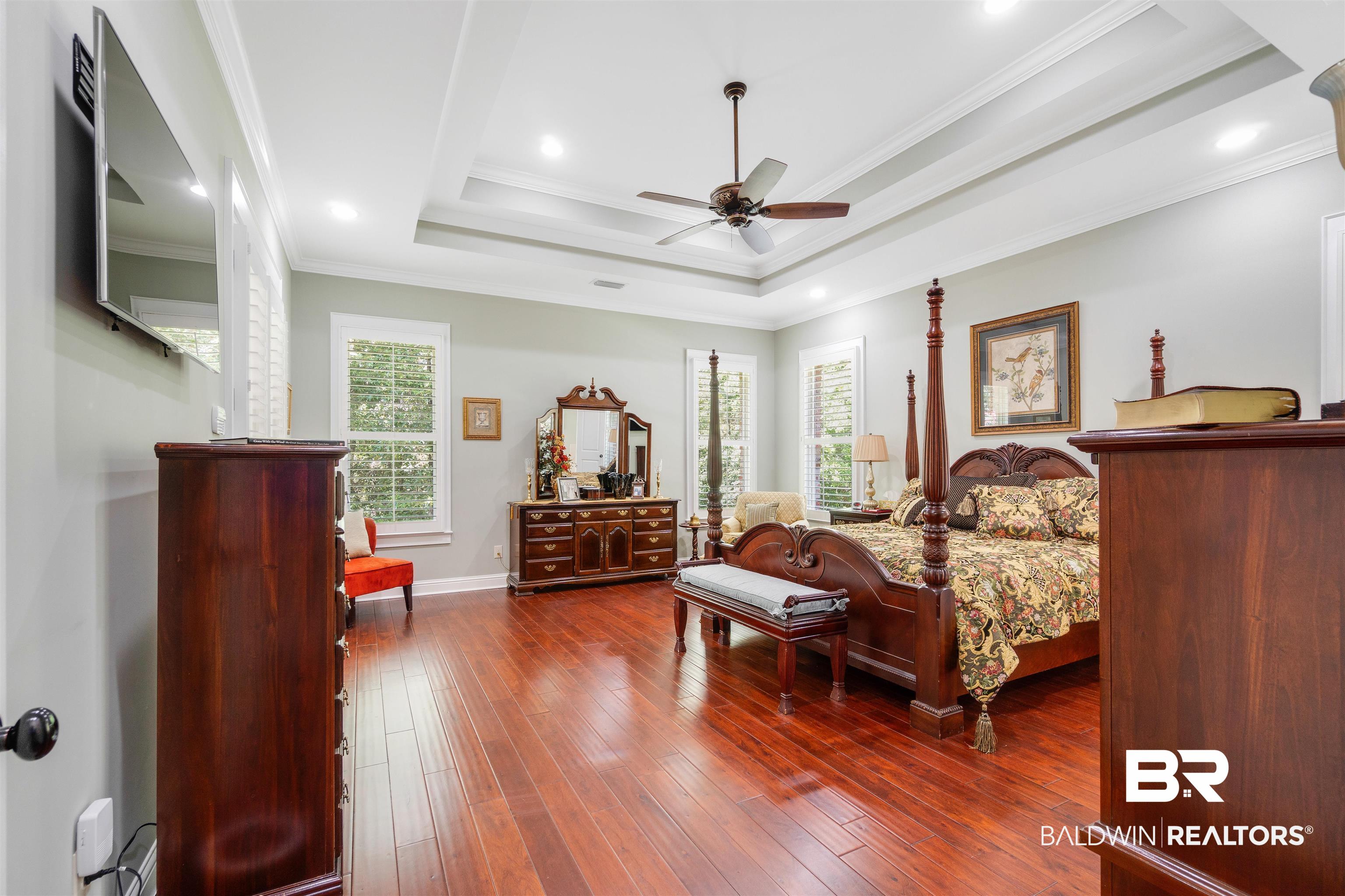 11281 Redfern Road Daphne, AL 36526 - Photo 24 of 80 Bedroom with crown molding, a raised ceiling, ceiling fan, and dark wood-type flooring