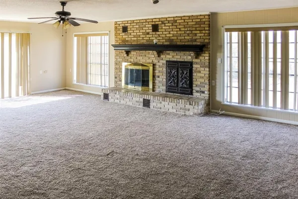 a view of an empty room with a fireplace and a window