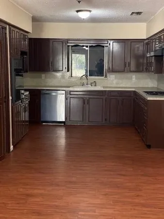 a kitchen with stainless steel appliances granite countertop a sink a stove and a refrigerator
