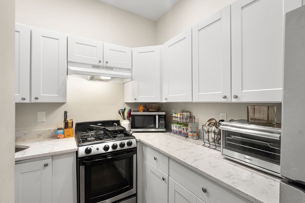 a kitchen with cabinets stainless steel appliances and a counter space