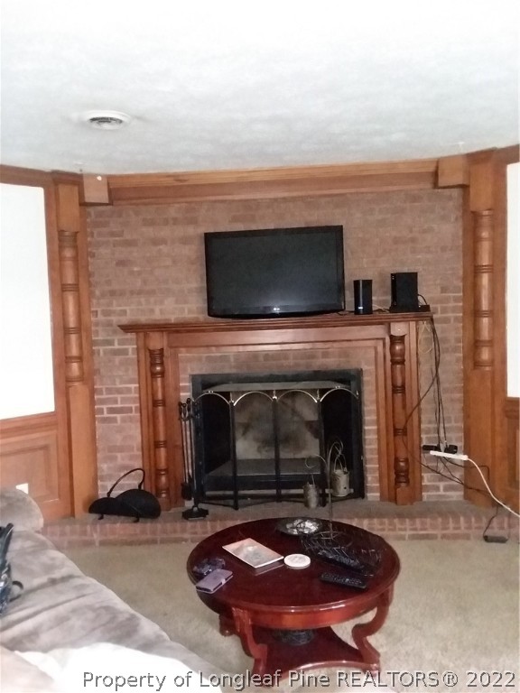 2560 Graham Road Fayetteville, NC 28304 - Photo 5 of 13 a living room with a fireplace a flat screen tv and a fireplace
