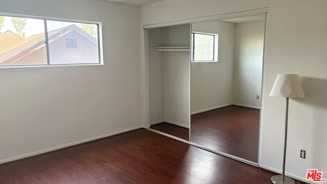 an empty room with wooden floor & closet