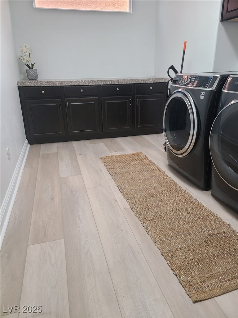 9629 Twin Rivers Court Las Vegas, NV 89139 - Photo 11 of 29 Laundry area with washing machine and clothes dryer, cabinet space, baseboards, and light wood-type flooring