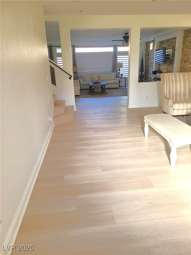 9629 Twin Rivers Court Las Vegas, NV 89139 - Photo 5 of 29 Hall featuring baseboards, stairway, and wood finished floors