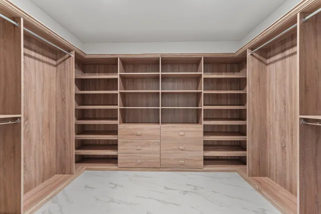 a view of walk in closet with empty racks