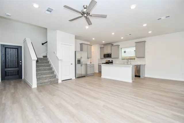 a view of a kitchen with wooden floor and electronic appliances