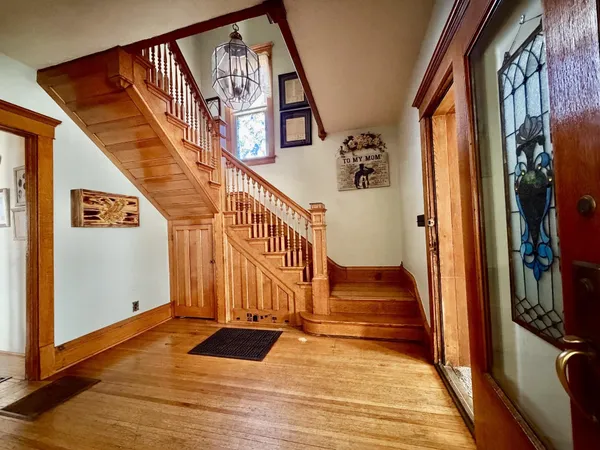 a view of staircase with railing and a chandelier