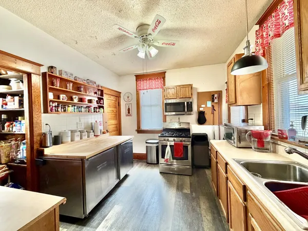 a kitchen that has a lot of cabinets a sink and appliances