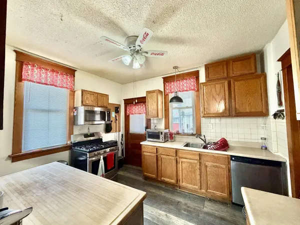 a kitchen with stainless steel appliances a stove top oven and a refrigerator