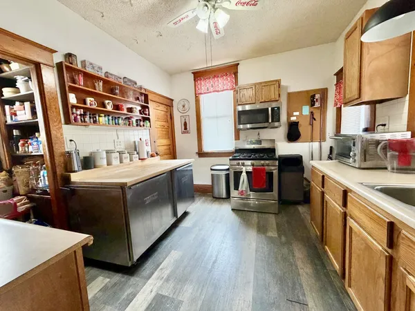 a kitchen that has a lot of cabinets stainless steel appliances and a chandelier