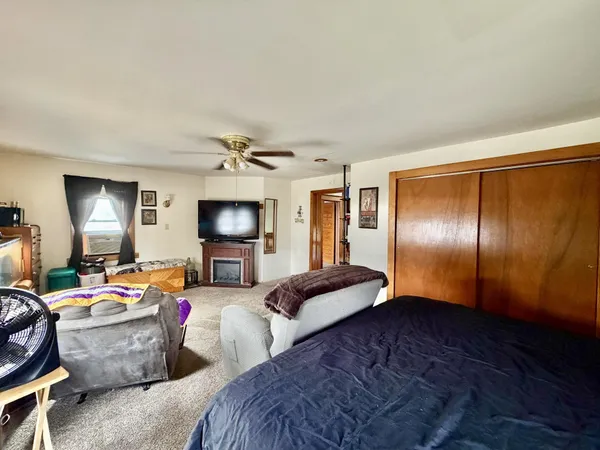 a bedroom with bed couch and window