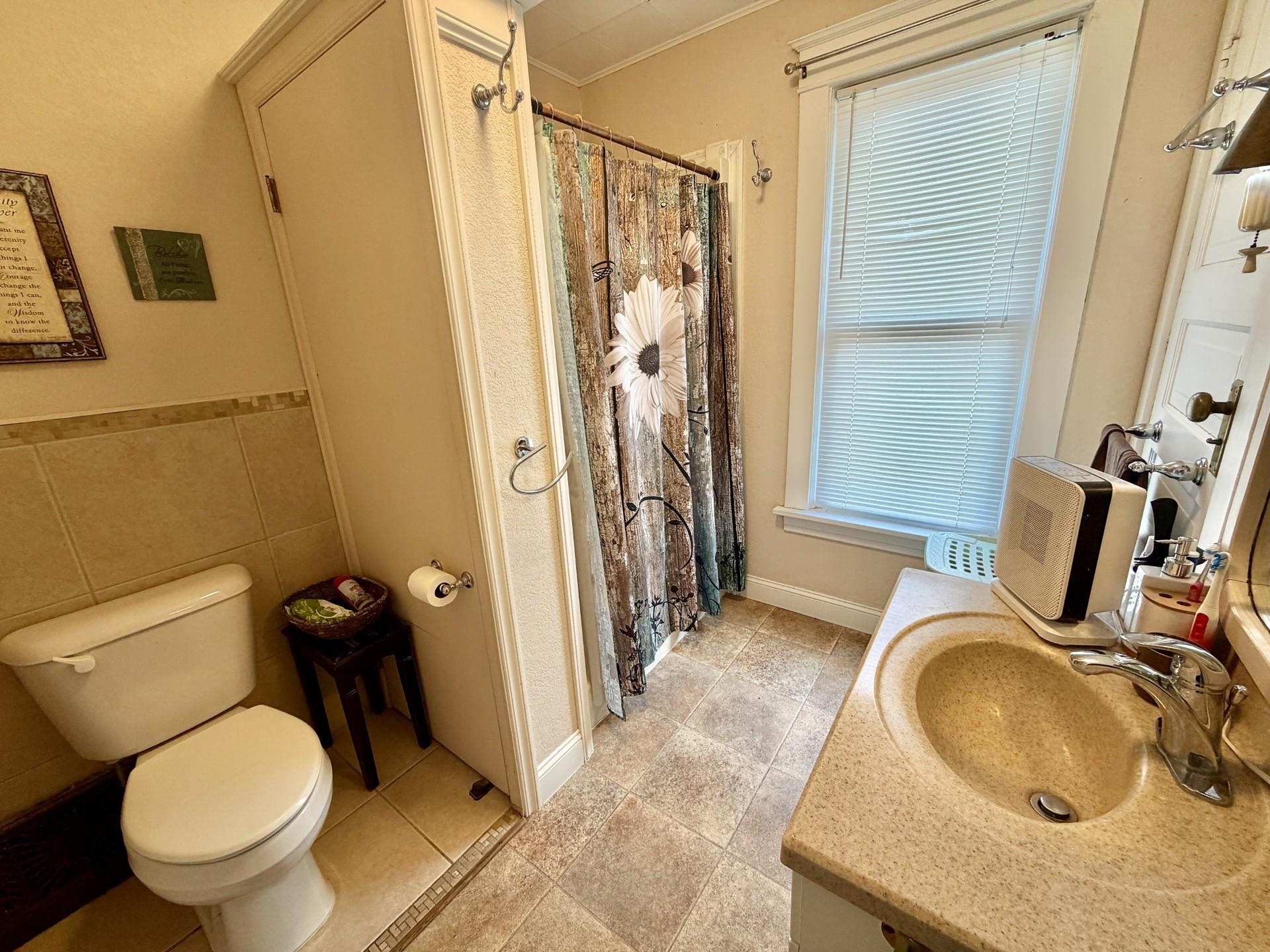 31 3rd Street Savanna, IL 61074 - Photo 40 of 42 a bathroom with a granite countertop toilet sink and mirror