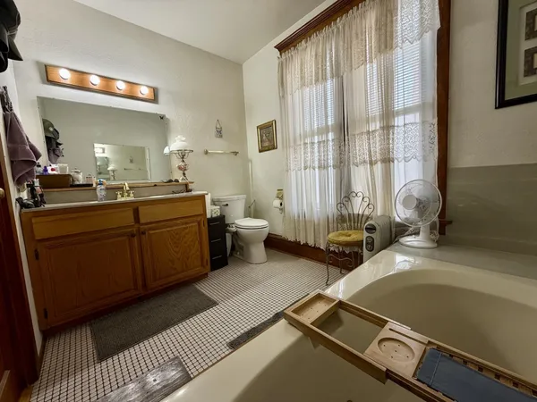 a bathroom with a tub sink and mirror